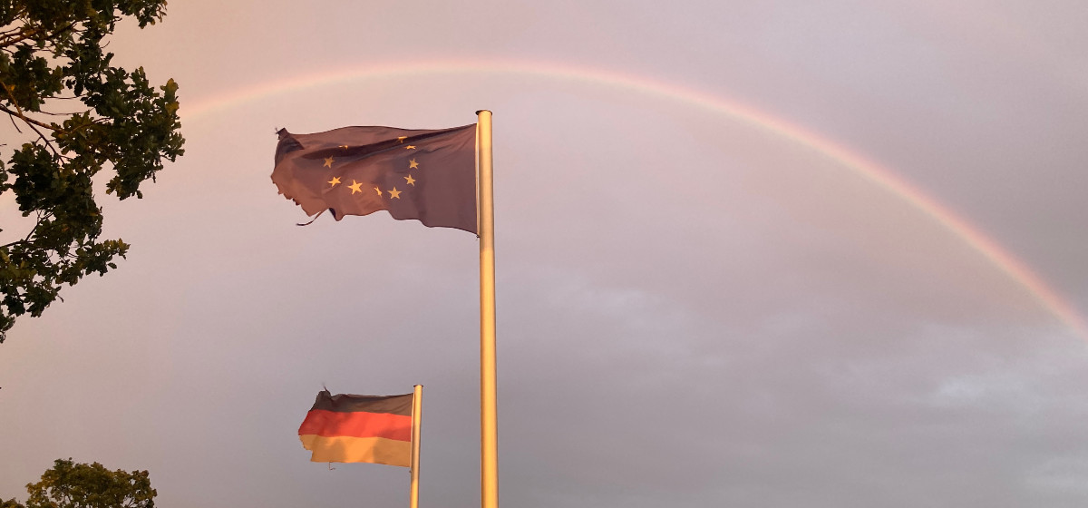 Netzwerken Deutschland und Europaflagge unter einem Regenbogen